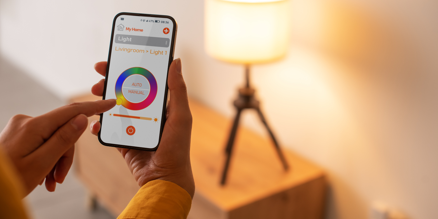 Women using smart phone to turn on lights - Making Your Home Smarter