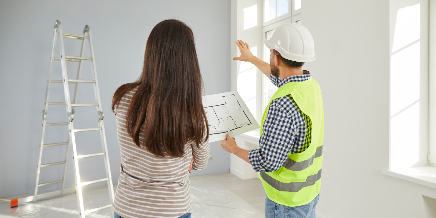 Meeting young female homeowner and foreman dressed in overalls and a protective helmet. Discussion of the details of repairs and changes in the layout of the house. Engineering and construction works. - How To Know If You’ve Hired the Wrong Contractor (and What To Do About It)