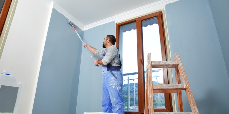 house painter painting room in blue